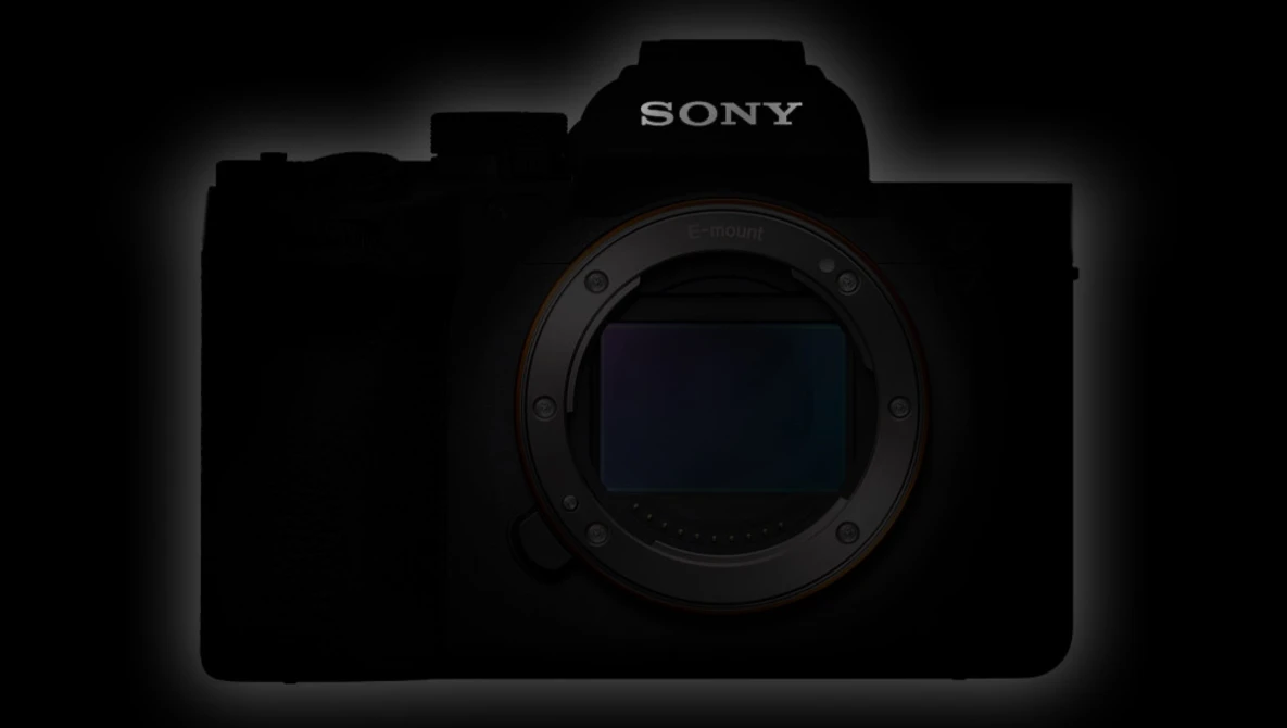 Silhouette of a Sony mirrorless camera body against a dark background, highlighting the lens mount and sensor area.