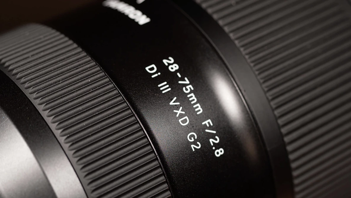 Close-up of a camera lens barrel showing focal length and aperture markings in macro detail.