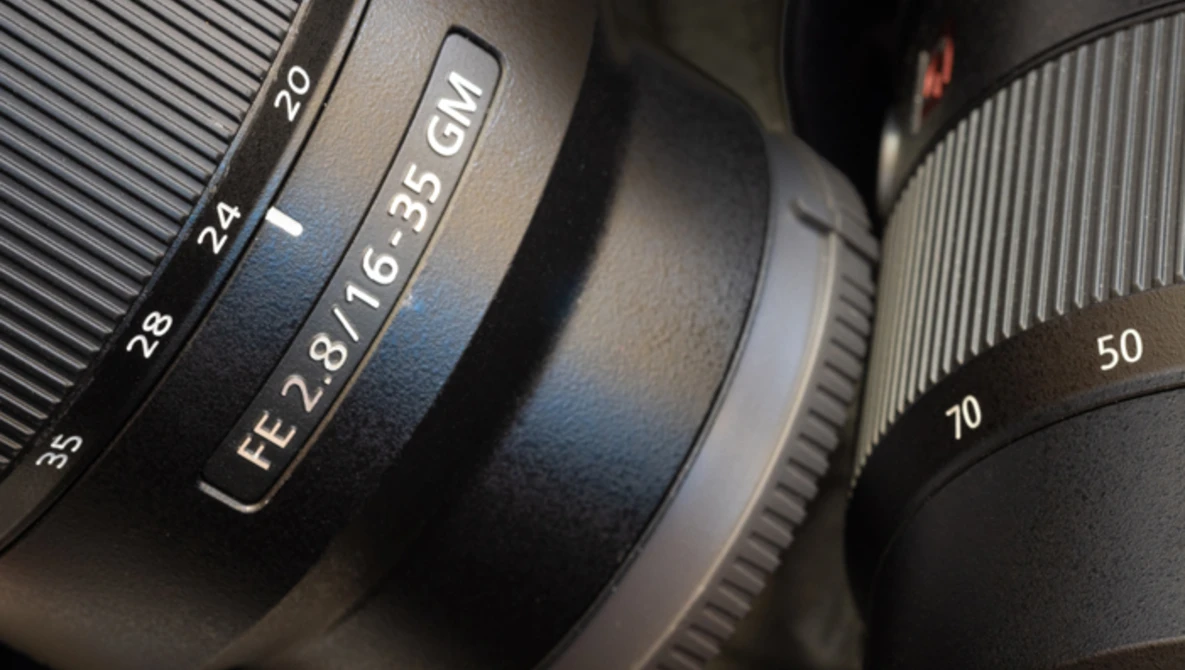 Close-up of camera lenses showing focal length markings and aperture specifications.