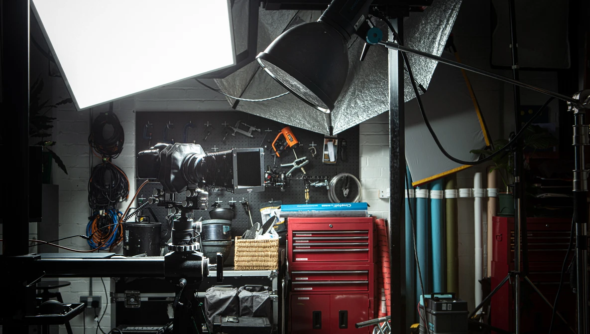 Professional film production studio with cinema camera, lighting rigs, and red equipment cases.