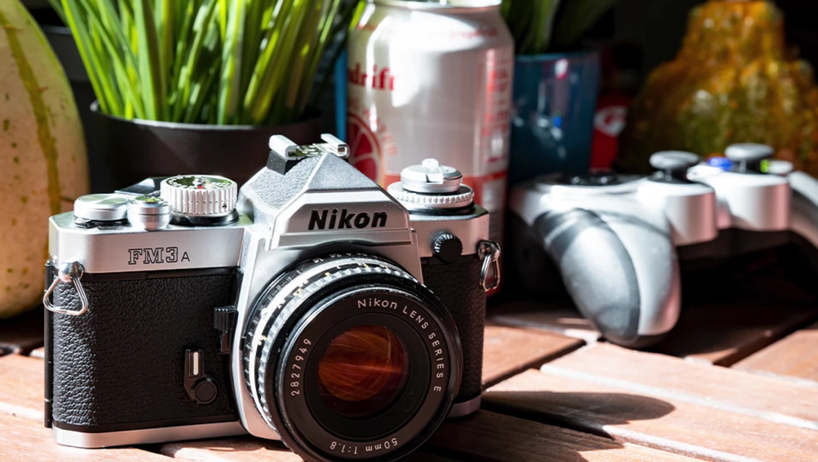 Vintage Nikon FM2A SLR camera with a Nikkor lens in natural window light.
