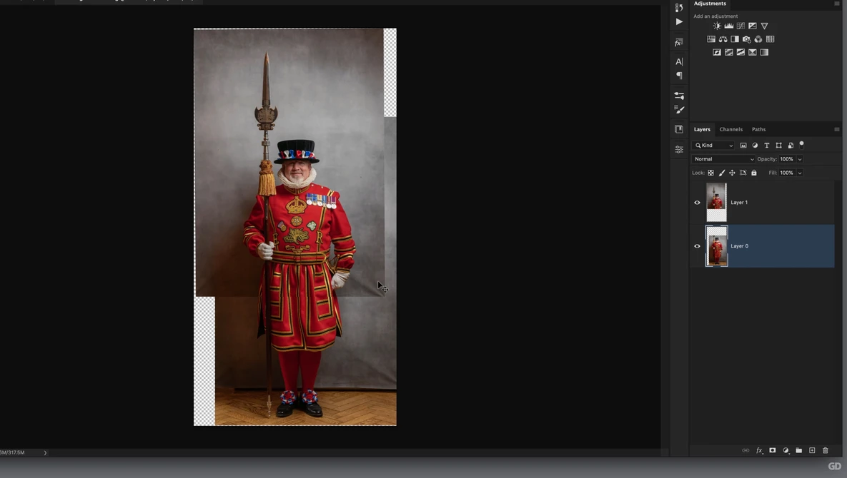 Man in elaborate red ceremonial uniform with feathered hat, holding ornamental staff, posed against neutral backdrop.