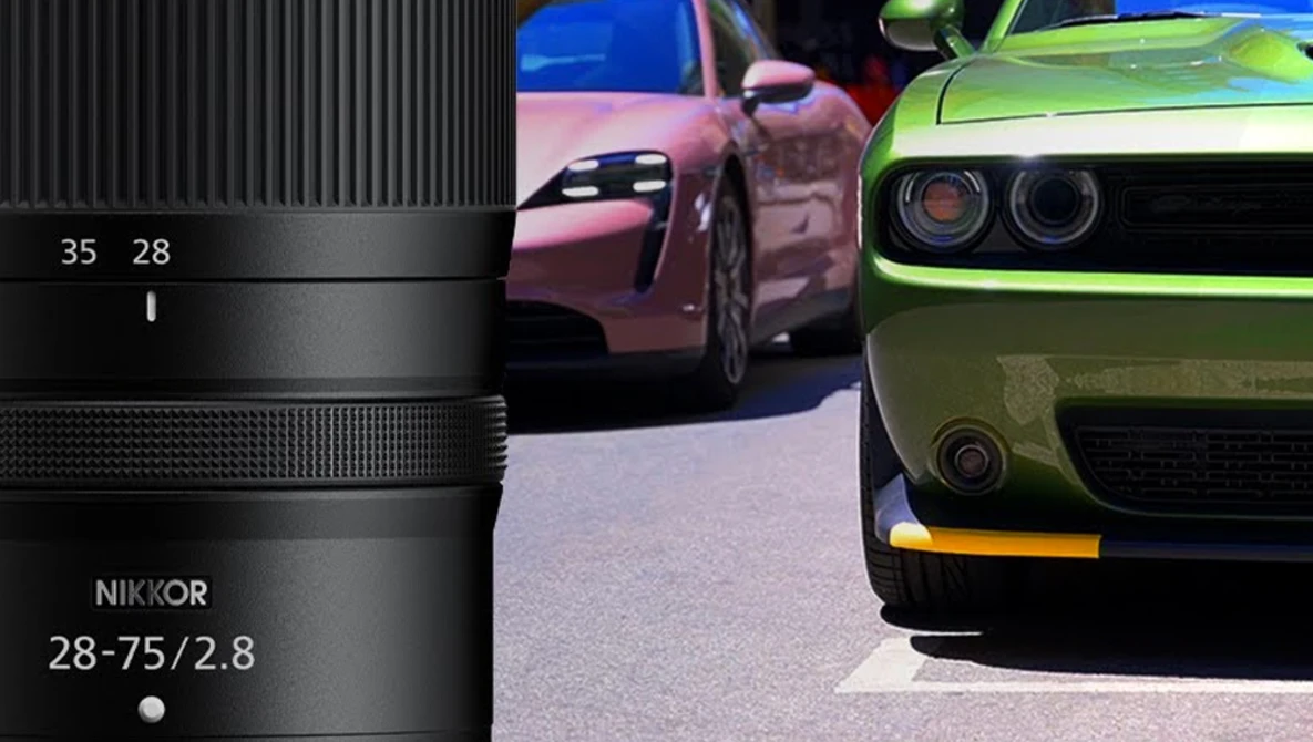 Nikon 28-75mm f/2.8 zoom lens displayed next to three colorful sports cars.