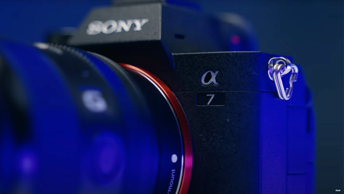 Sony Alpha 7 mirrorless camera displayed with lens and blue dramatic lighting.
