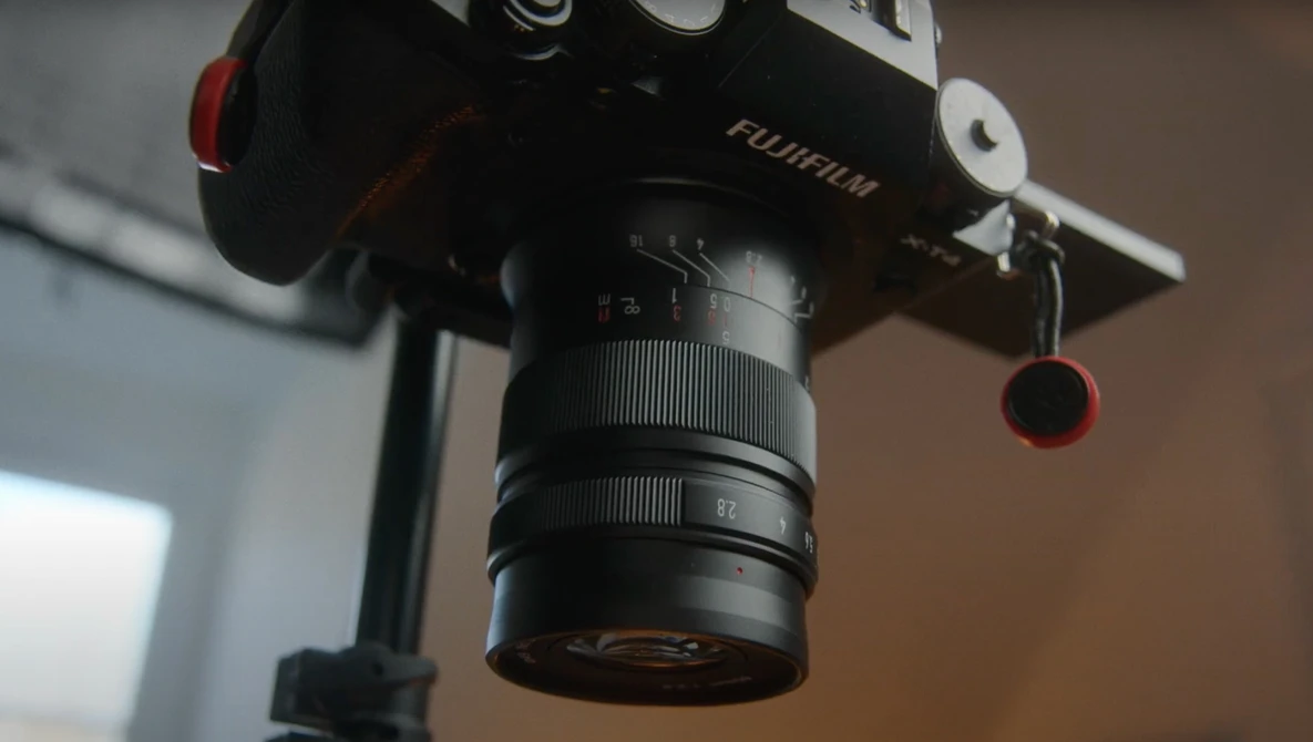 Fujifilm camera mounted on a tripod with a telephoto lens attached, shown in close-up detail.
