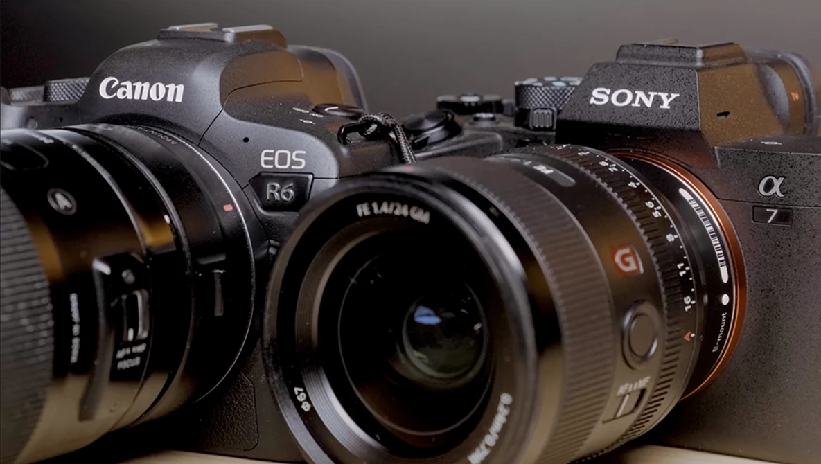 Canon EOS R6 and Sony Alpha a7 mirrorless cameras displayed side-by-side with prime lenses attached.