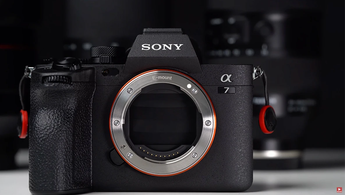 Sony a7 mirrorless camera body with red accents and open lens mount displayed against dark background.