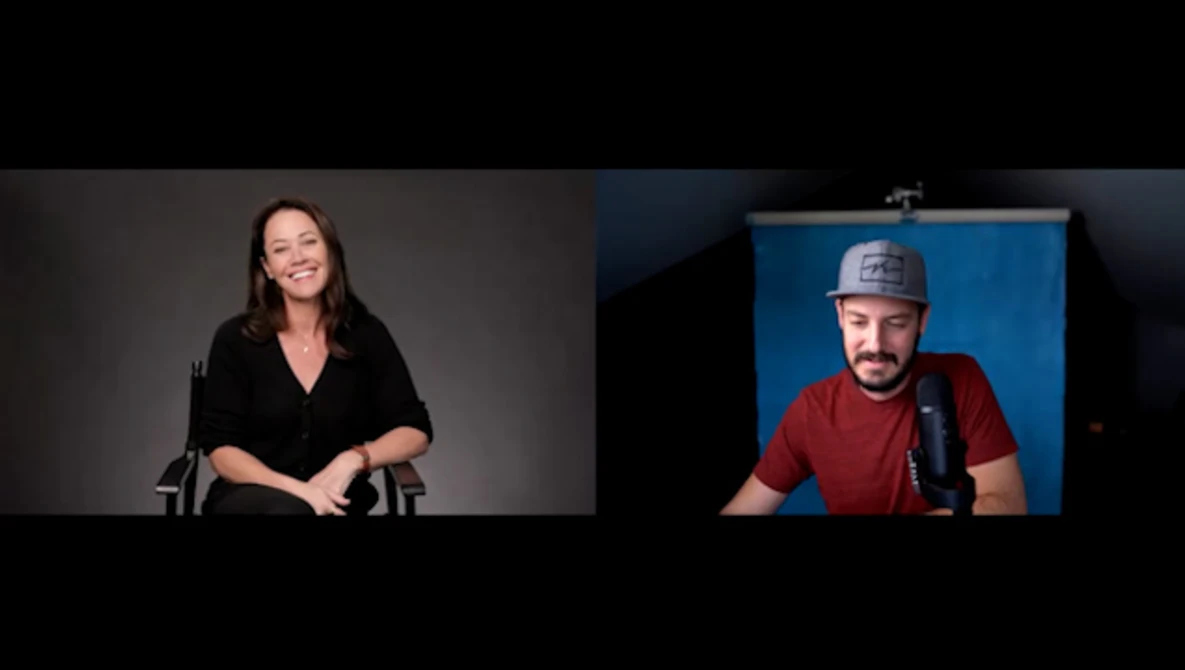 Split-screen video interview showing woman on left in black shirt and man on right wearing red shirt and cap with microphone.