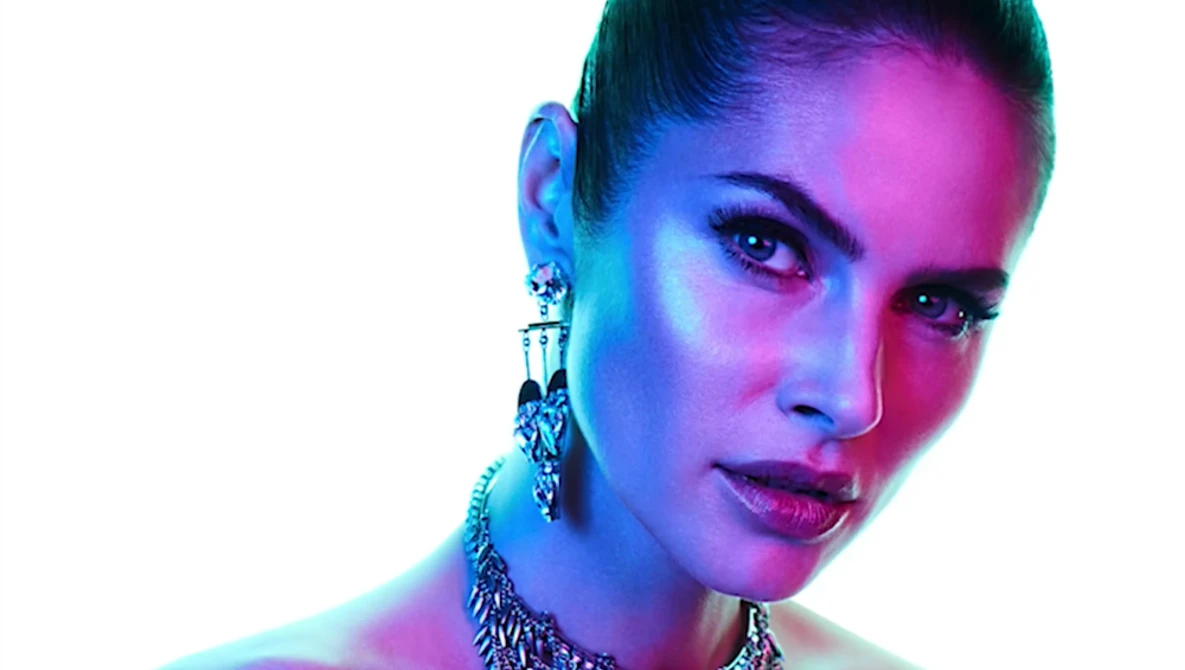 Woman's face lit with vibrant neon blue and pink gradient lighting against white background.
