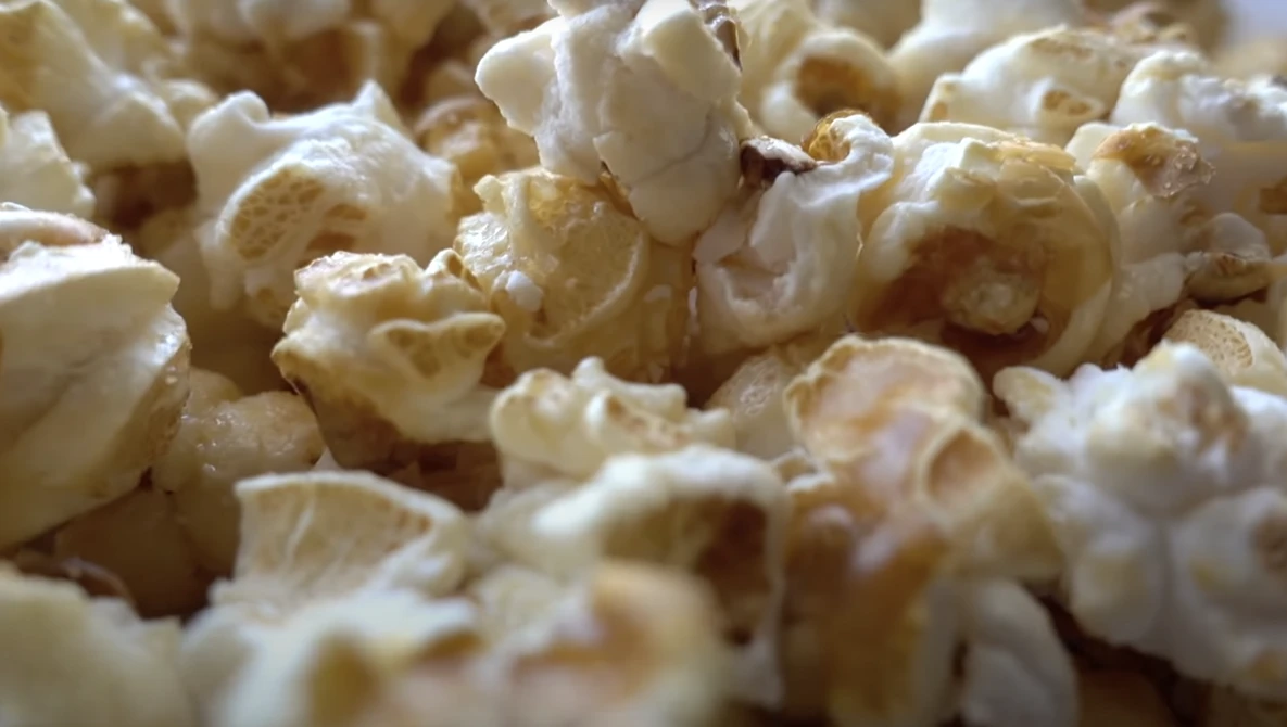 Close-up of freshly popped popcorn with white and golden kernels filling the frame.