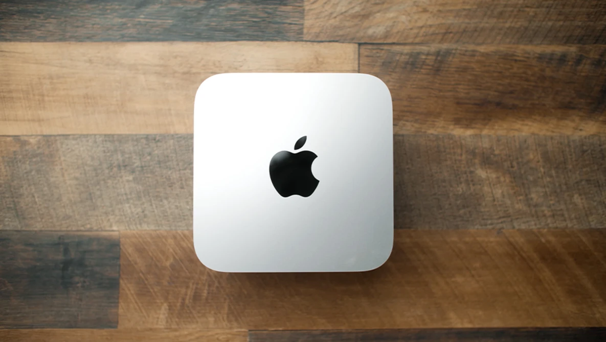 Mac mini desktop computer on wooden surface. Studio product shot.