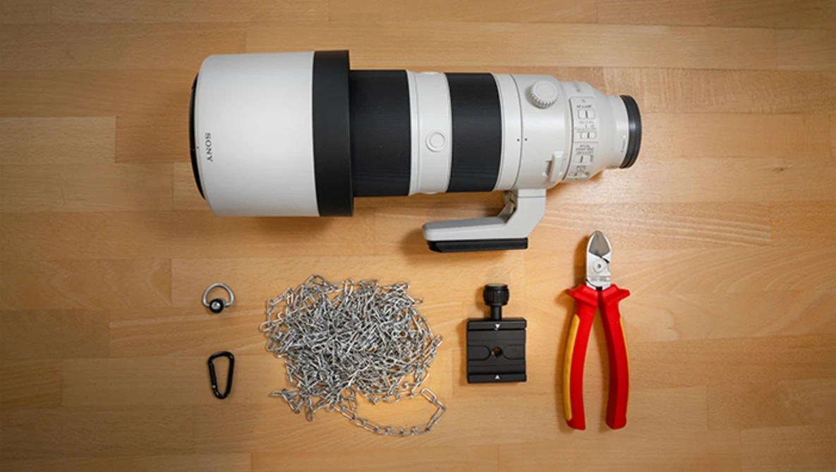 Telephoto lens with accessories arranged on wooden surface.