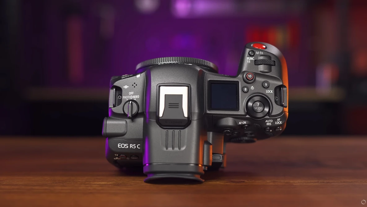 Three Canon EOS mirrorless cameras arranged to show their top and side profiles against a blurred purple and orange background.