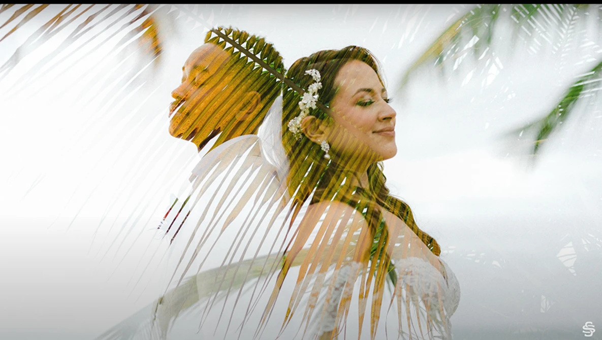 Woman with braided hair and white flowers in profile, with double exposure showing grass and natural landscape.