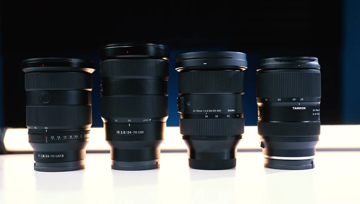 Four camera lenses arranged in a row against a dark background with dramatic side lighting.