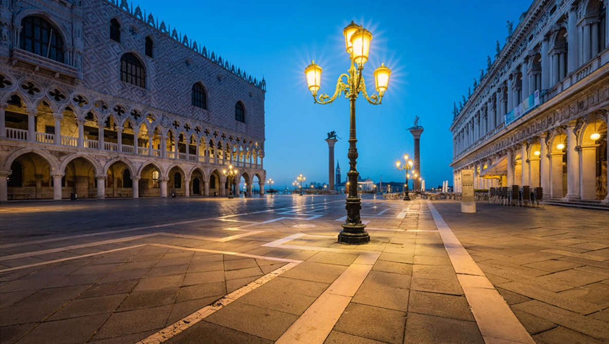 Ornate Venetian plaza at twilight with illuminated lamp post and historic buildings.