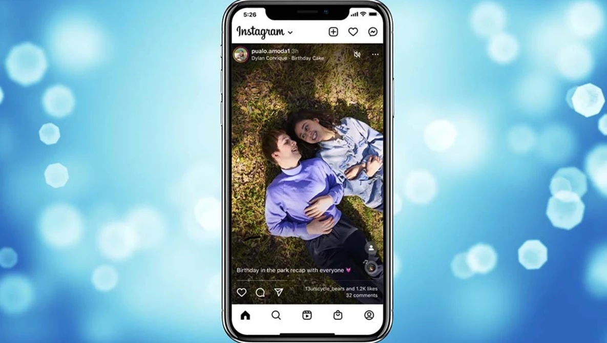 Screenshot of an Instagram post showing two people lying on golden grass in warm sunlight.