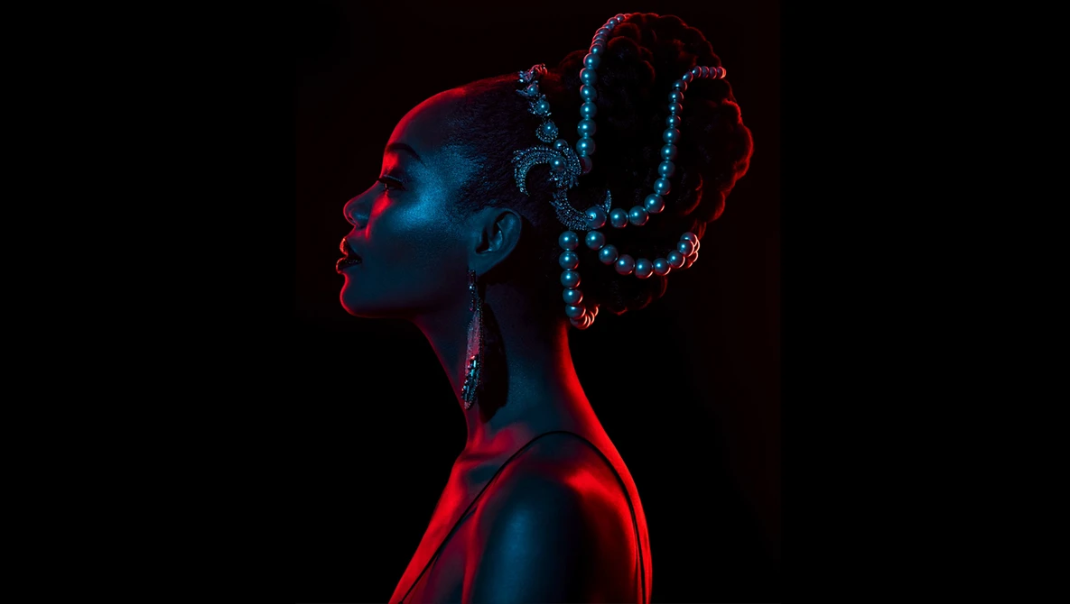 Profile portrait with neon red and blue lighting on dark background.