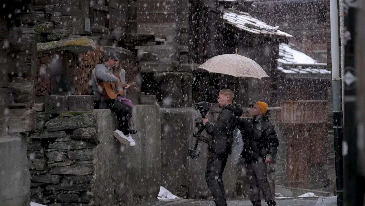 People with umbrellas walking in heavy rain on a wet urban street.