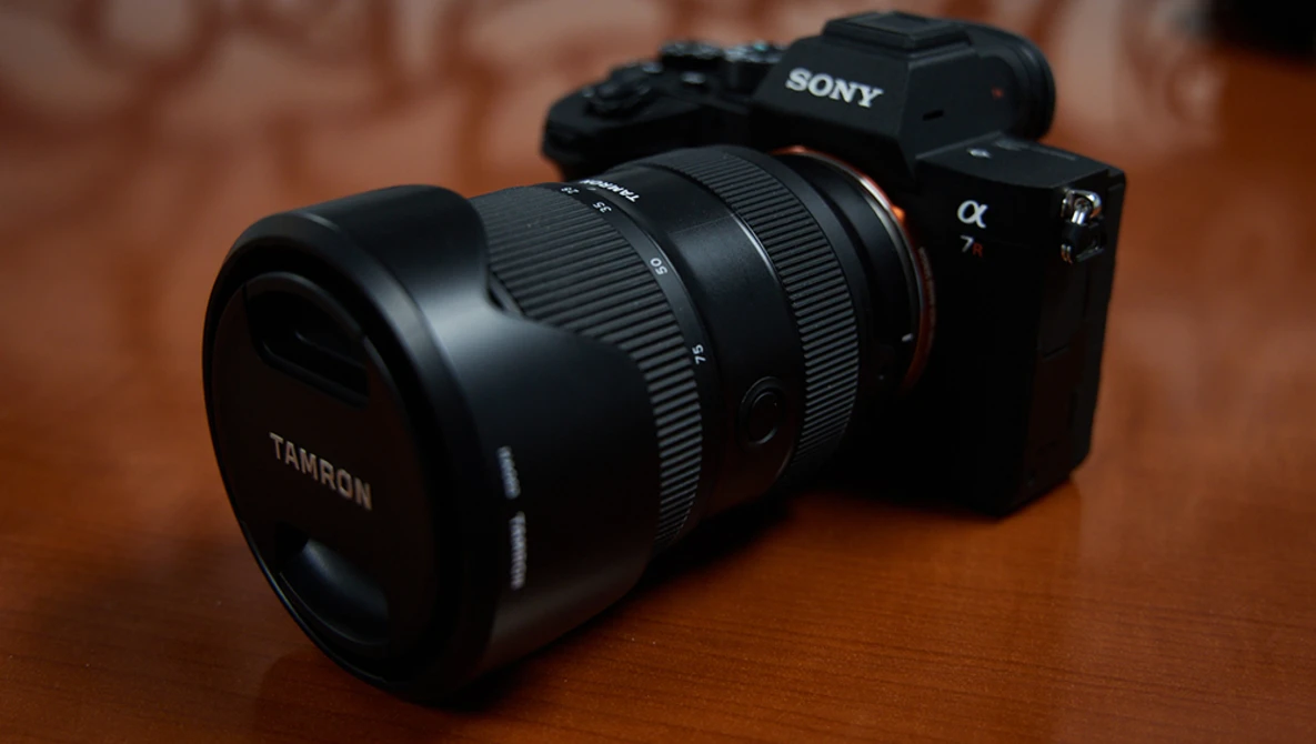Sony mirrorless camera with Tamron lens mounted on wooden surface.