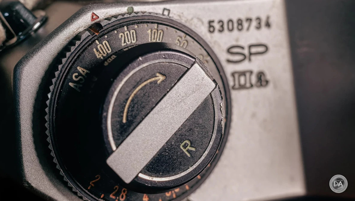 Close-up of a vintage light meter dial with exposure compensation scale and selector needle.