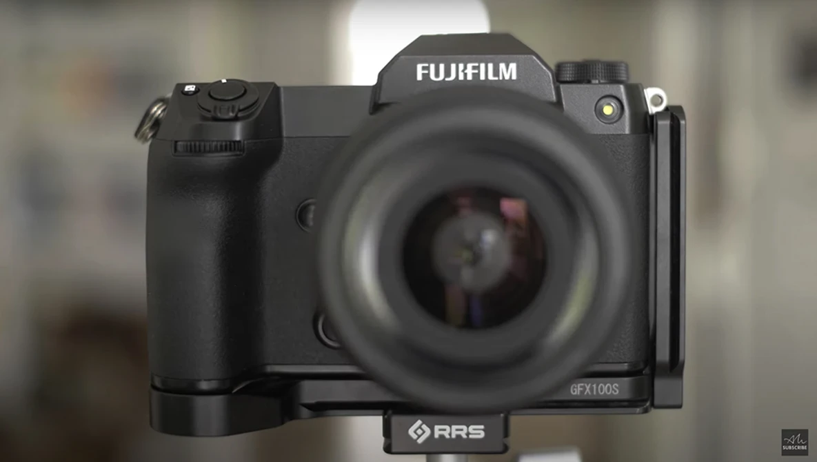 Fujifilm GFX100S medium format camera with RRS L-bracket mounted, shown front-on with blurred background.