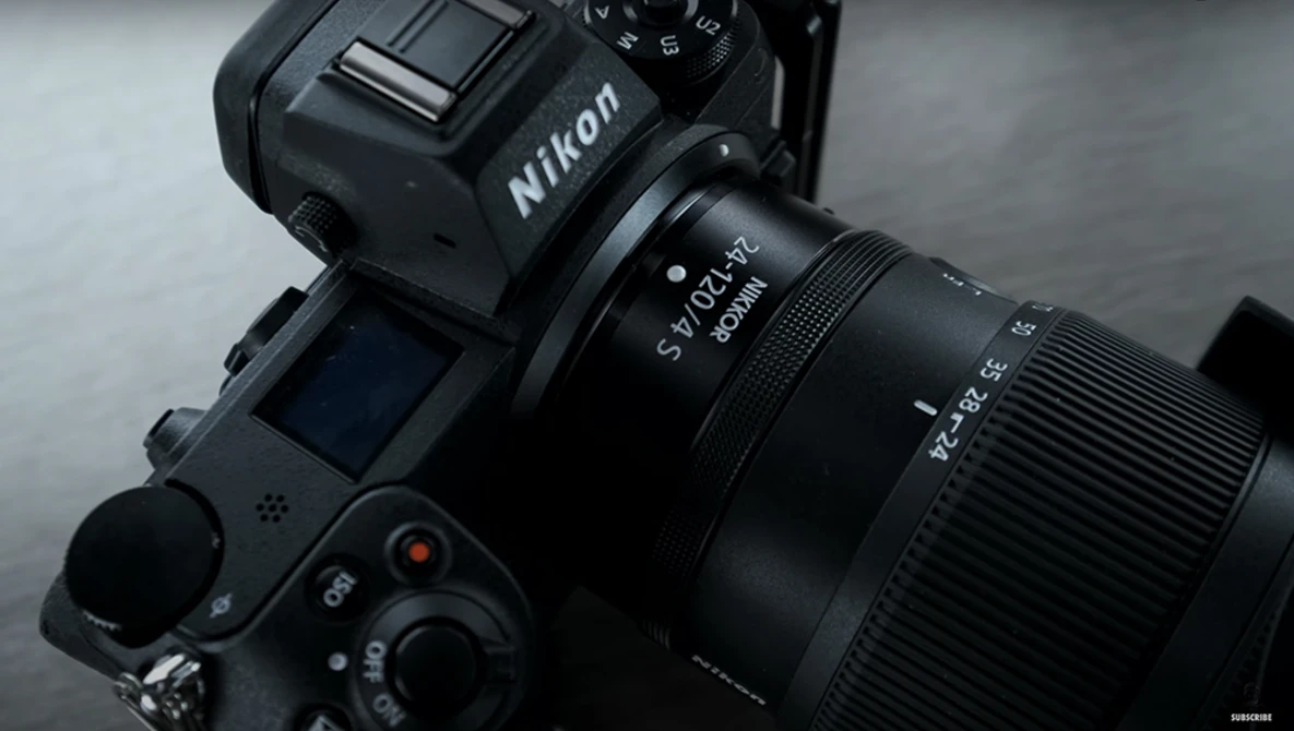 Nikon DSLR camera with attached telephoto lens against a gray background.
