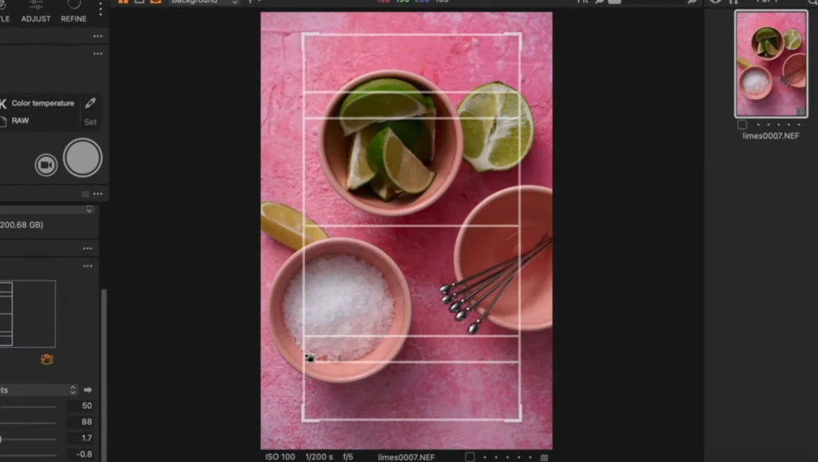 Screenshot of photo editing software displaying a styled flat lay with cocktail ingredients on a pink background.