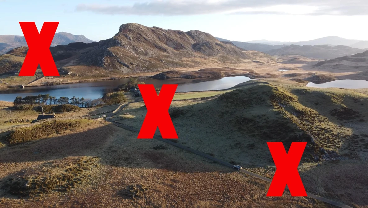 Aerial landscape showing volcanic terrain, multiple lakes, and mountains with three red X marks overlaid on the scene.