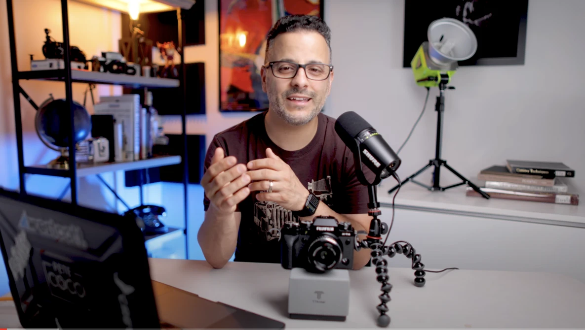 Content creator speaking into a microphone at a desk in a home studio setup.