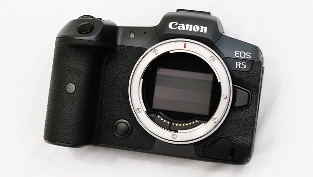 Canon EOS R5 mirrorless camera body with open sensor showing electronic components against white background.