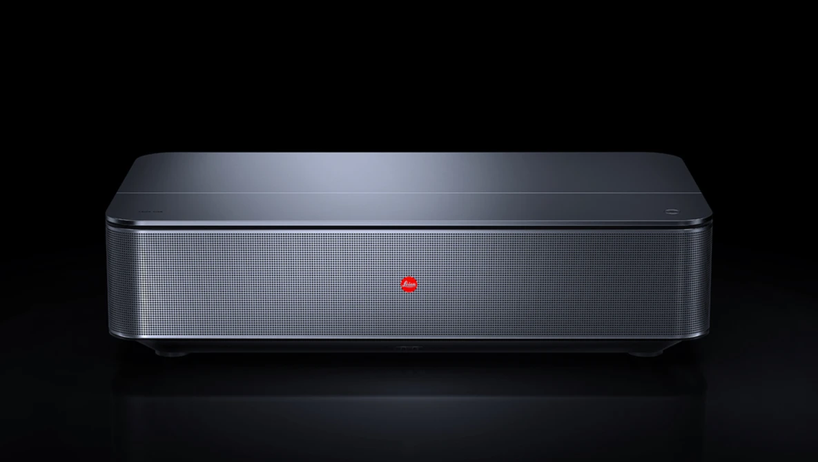 Sleek gray rectangular device with mesh speaker grille and minimalist design against black background.