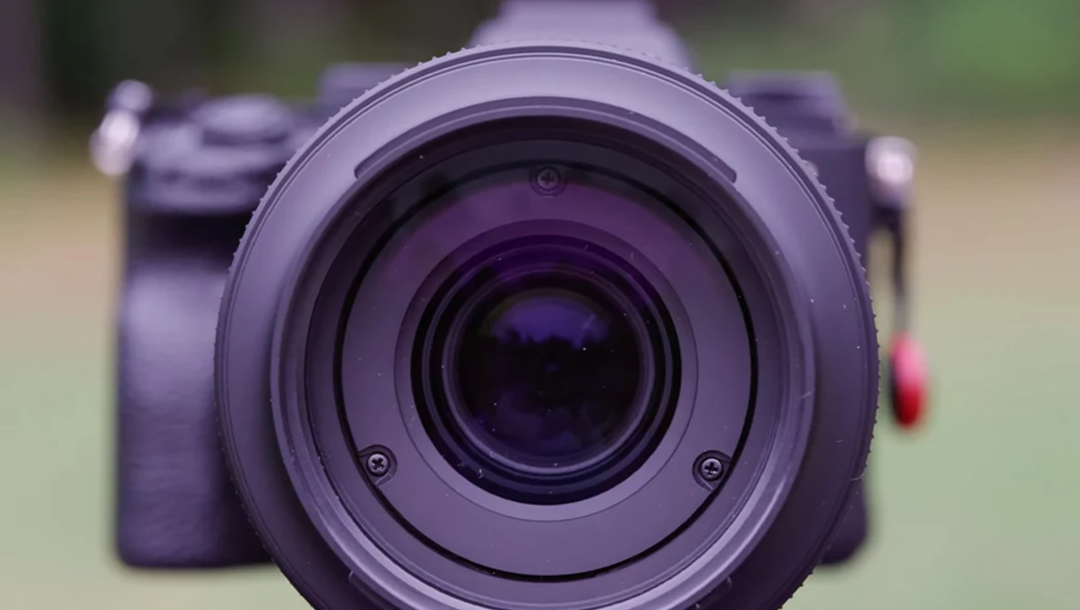Close-up of a purple camera lens with concentric glass elements visible through the front element.