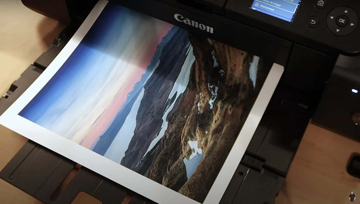 Canon printer outputting a landscape photograph with dramatic sky and rocky terrain.