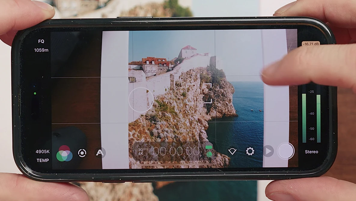 Screenshot of smartphone camera app displaying a coastal cliff landscape with visible exposure and focus controls.