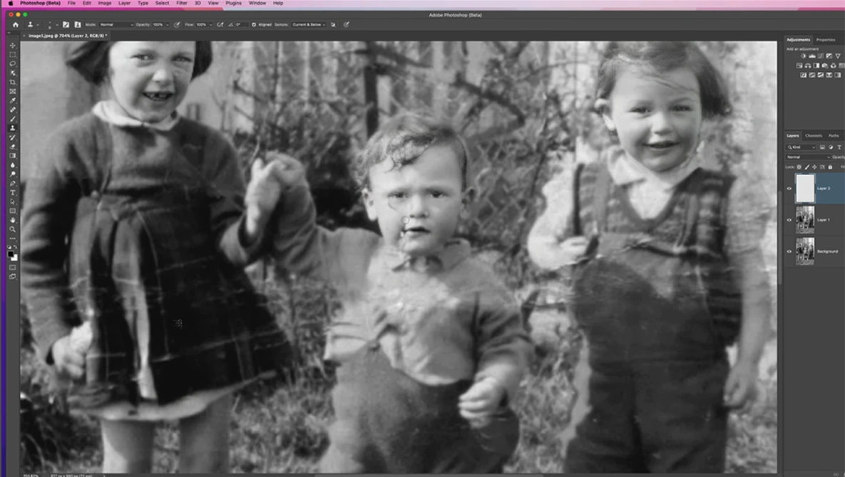 Four young children standing outdoors among bare branches, dressed in vintage clothing with slight smiles toward the camera.