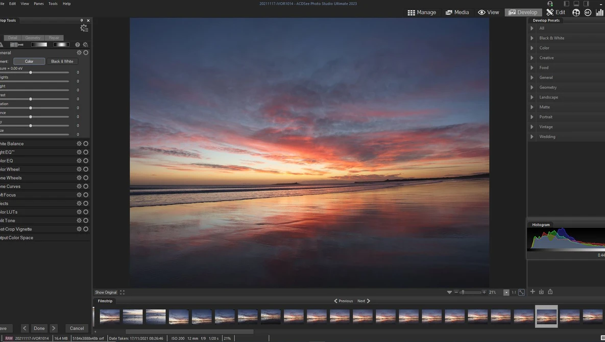 Screenshot of photo editing software displaying a vibrant sunset over calm water with warm orange and pink tones.