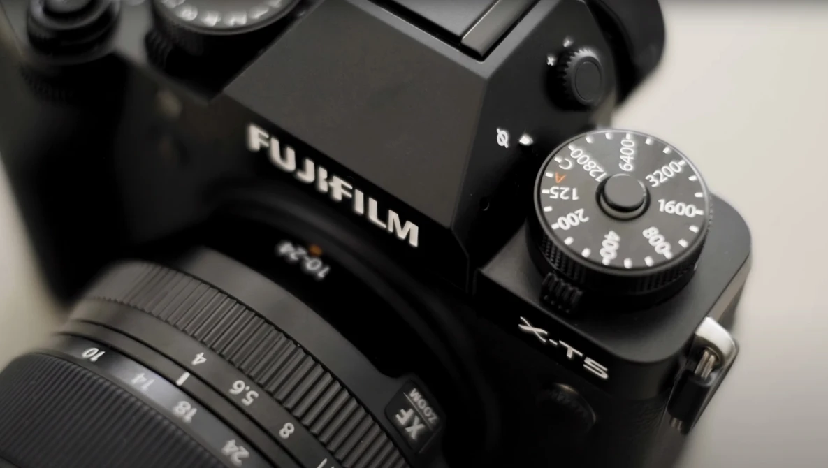 Fujifilm X-T5 camera with attached lens and exposure compensation dial visible on top plate.