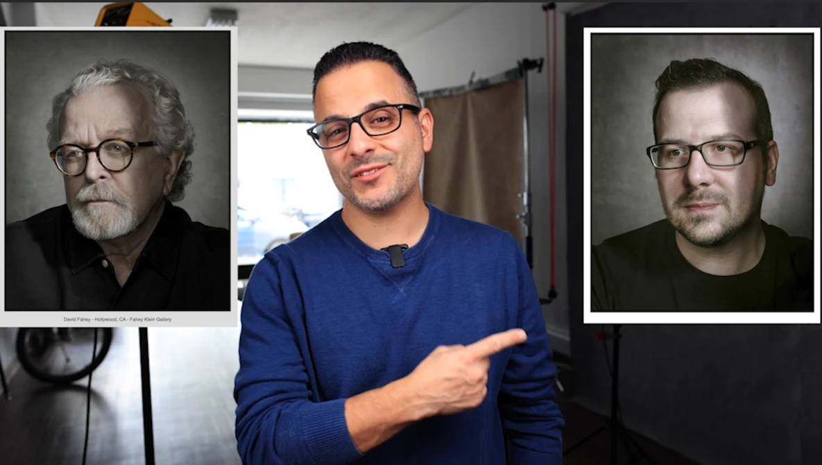 Man in blue shirt pointing to two portrait headshots displayed on either side of him.