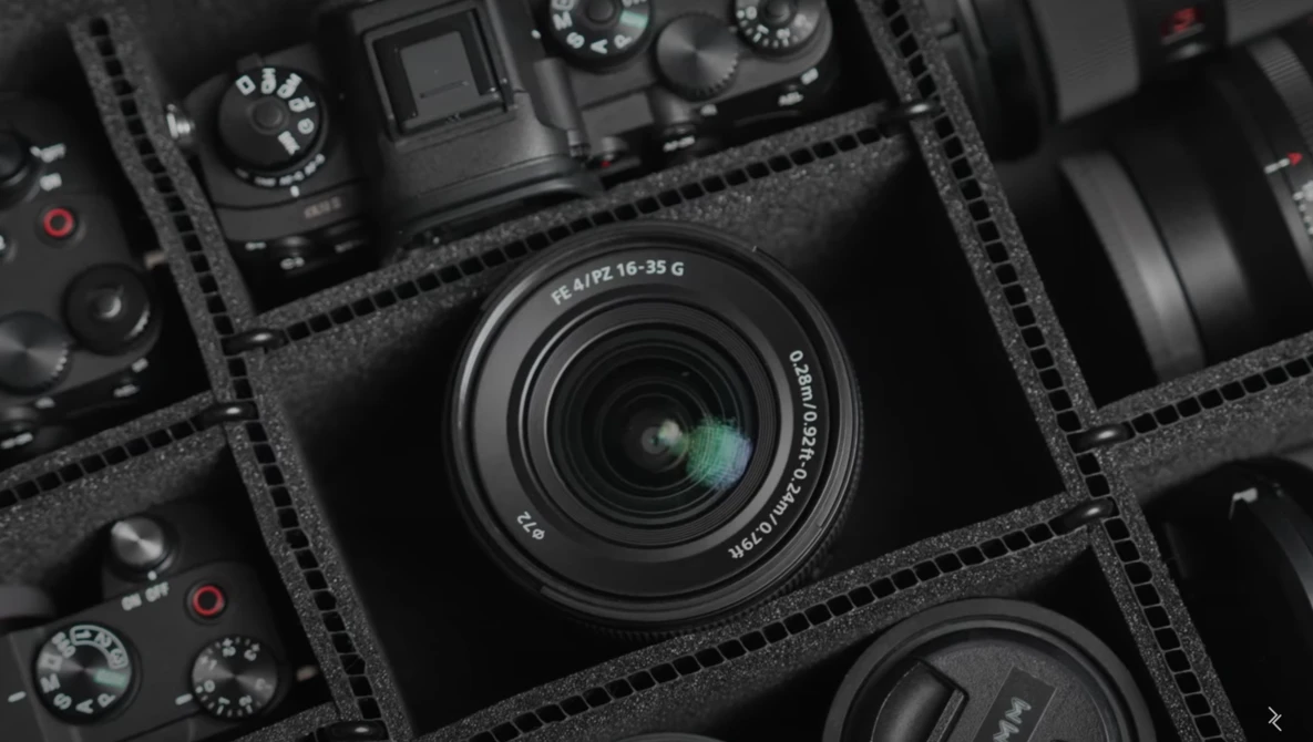 Leica 18-25mm zoom lens displayed in foam equipment case with camera bodies and accessories.