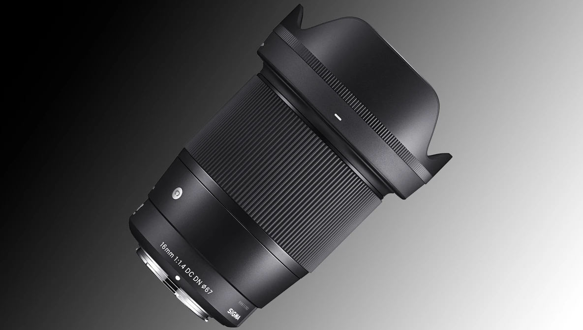 Black telephoto lens with hood mounted, displayed at an angle against a gradient gray background.