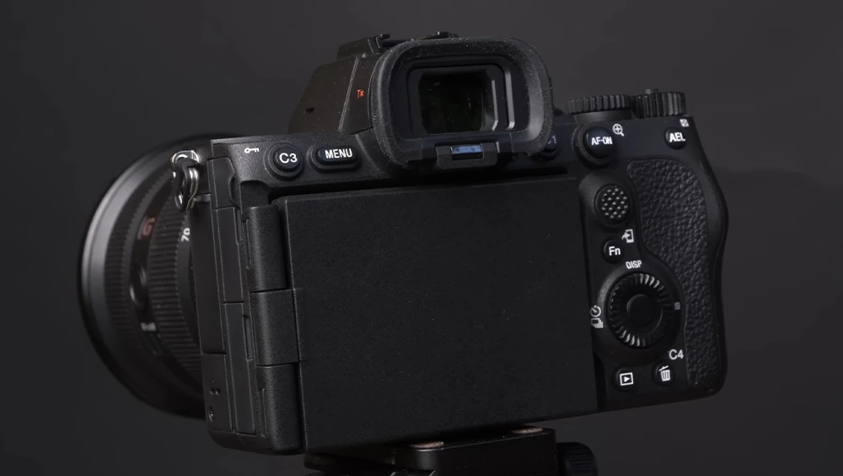 Professional mirrorless camera shown from rear three-quarter angle against dark background.
