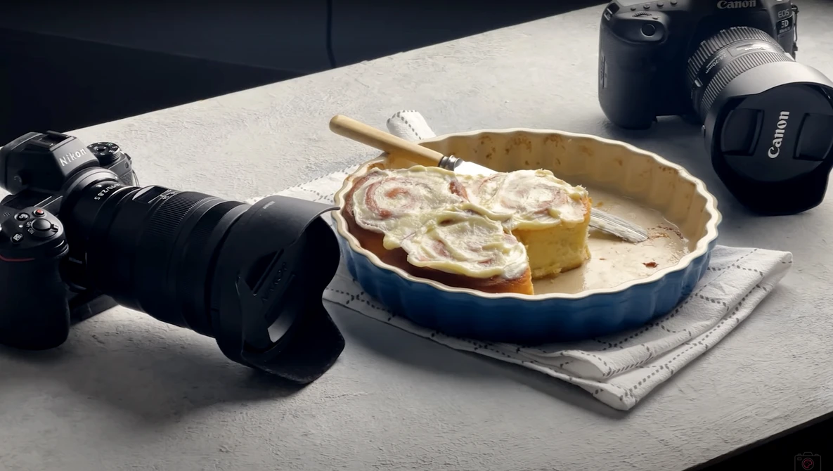 Flat lay of photography equipment and a baked pie on a concrete surface.