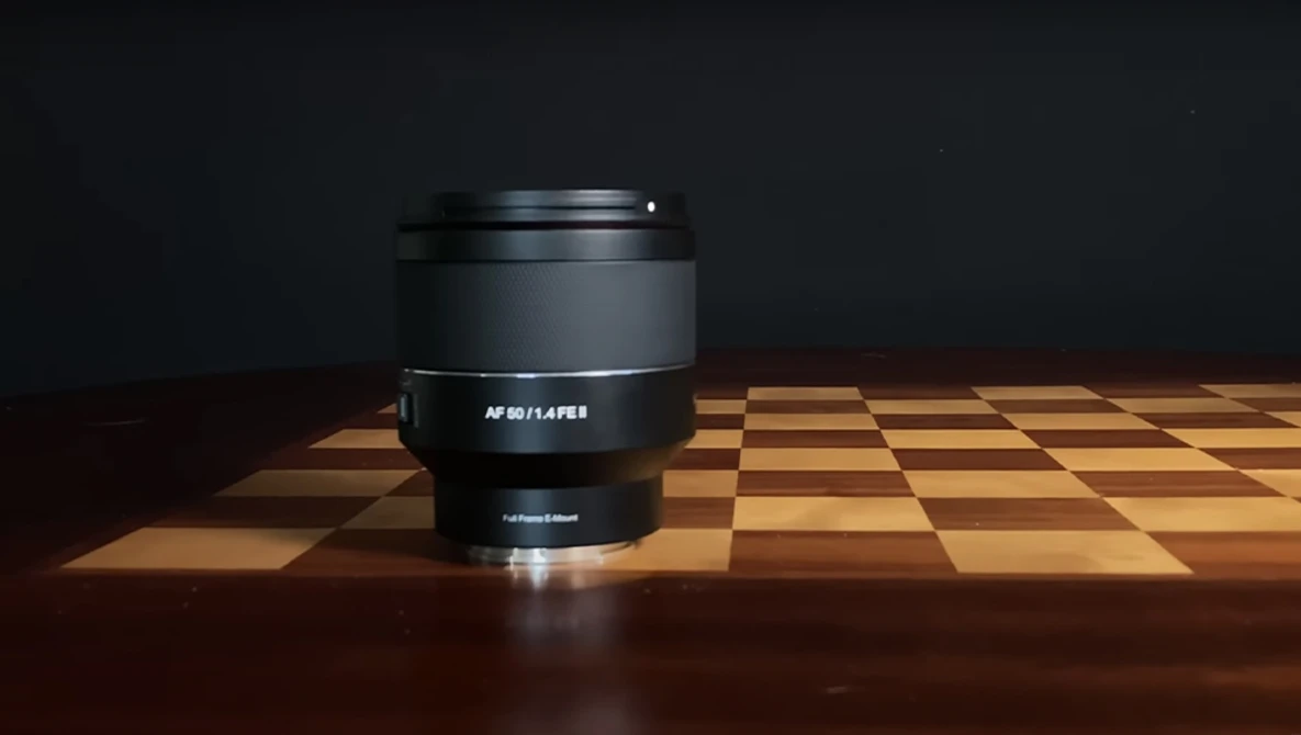 Camera lens mounted on wooden checkerboard surface against dark background.