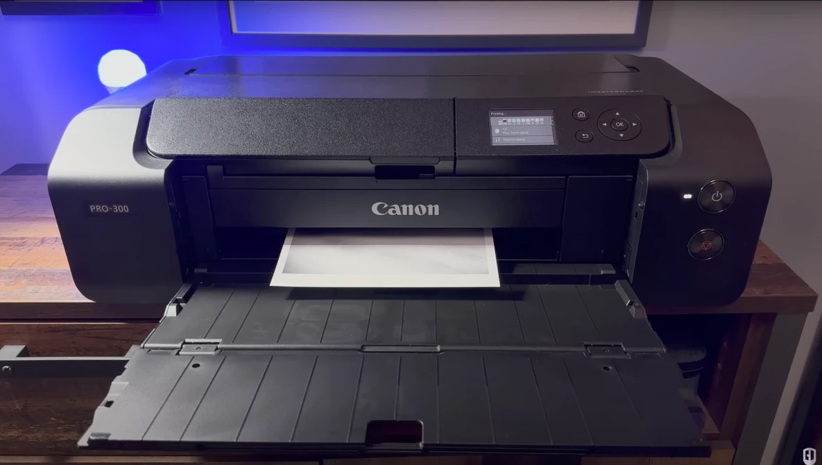 Canon PRO-500 large-format printer with open output tray on wooden desk.