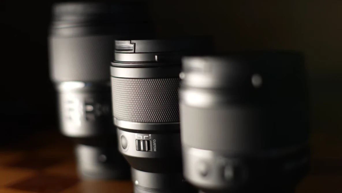 Collection of camera lenses arranged with selective focus and dramatic side lighting.
