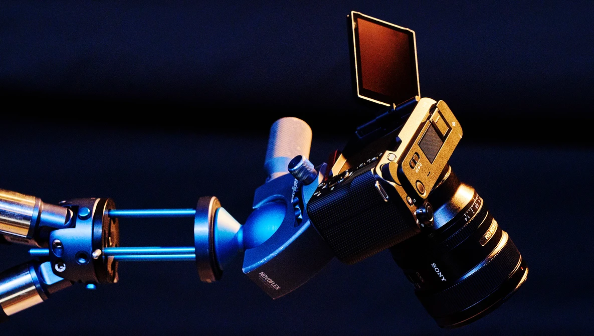 Professional cinema camera rig with blue and gold lighting equipment against dark background.
