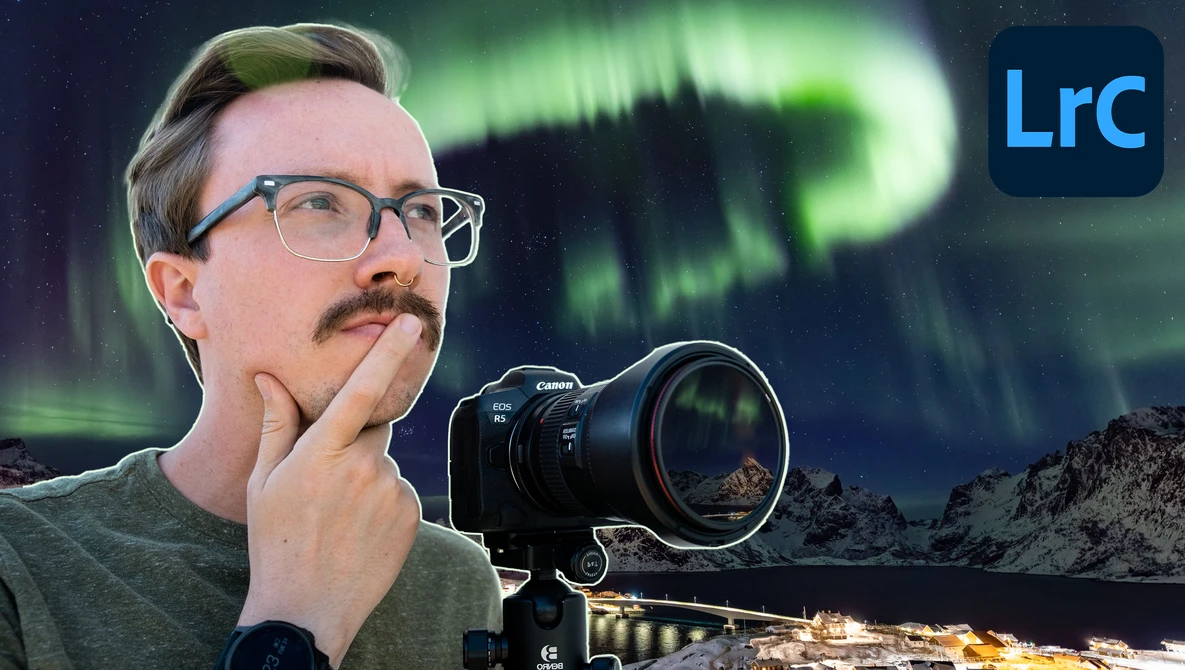 Photographer holding Canon mirrorless camera with telephoto lens, gazing upward at aurora borealis overhead.