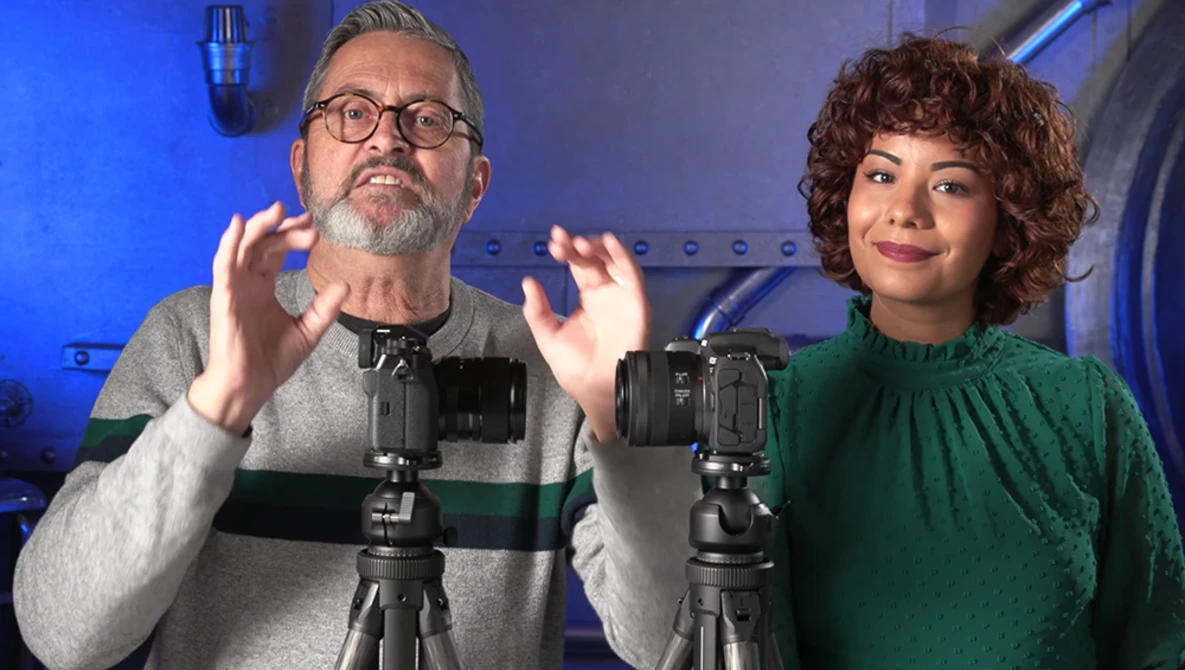 Two content creators demonstrating camera equipment on tripods in a studio setting with blue lighting.