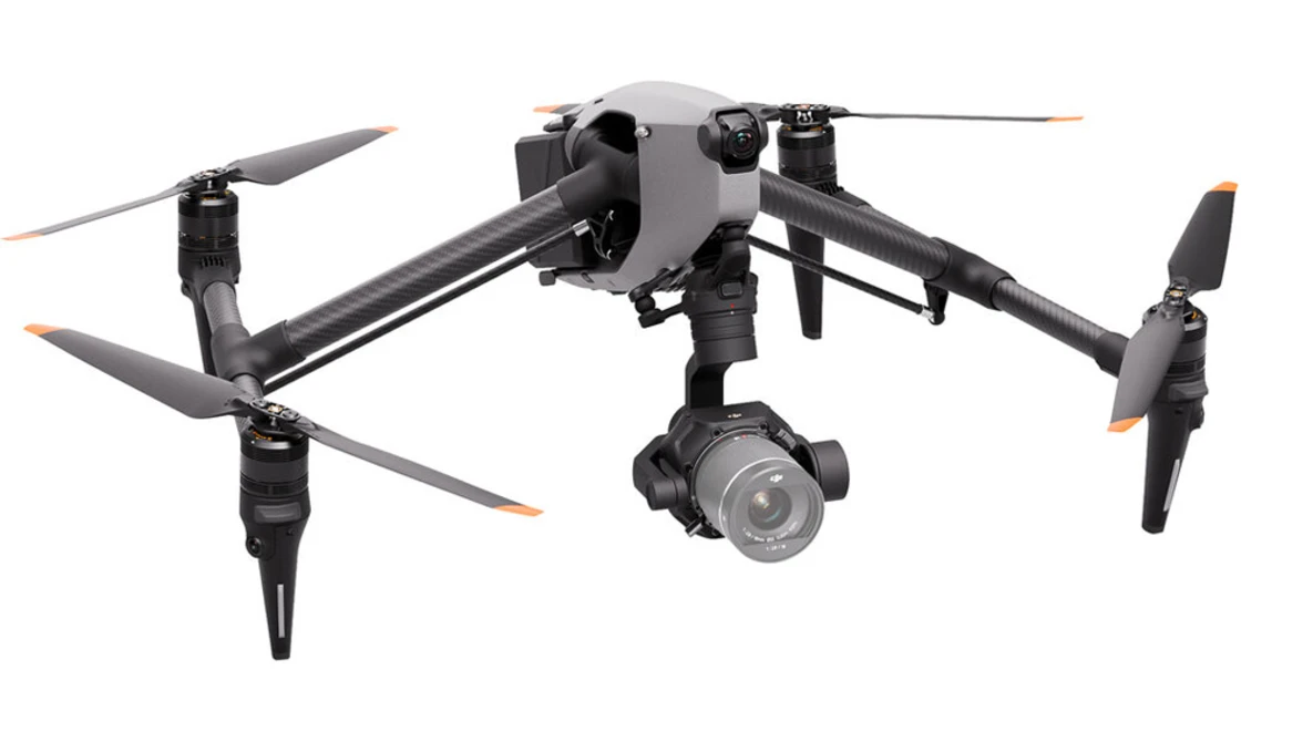 Professional quadcopter drone with retractable landing gear and mounted camera gimbal, shown in hover position against white background.